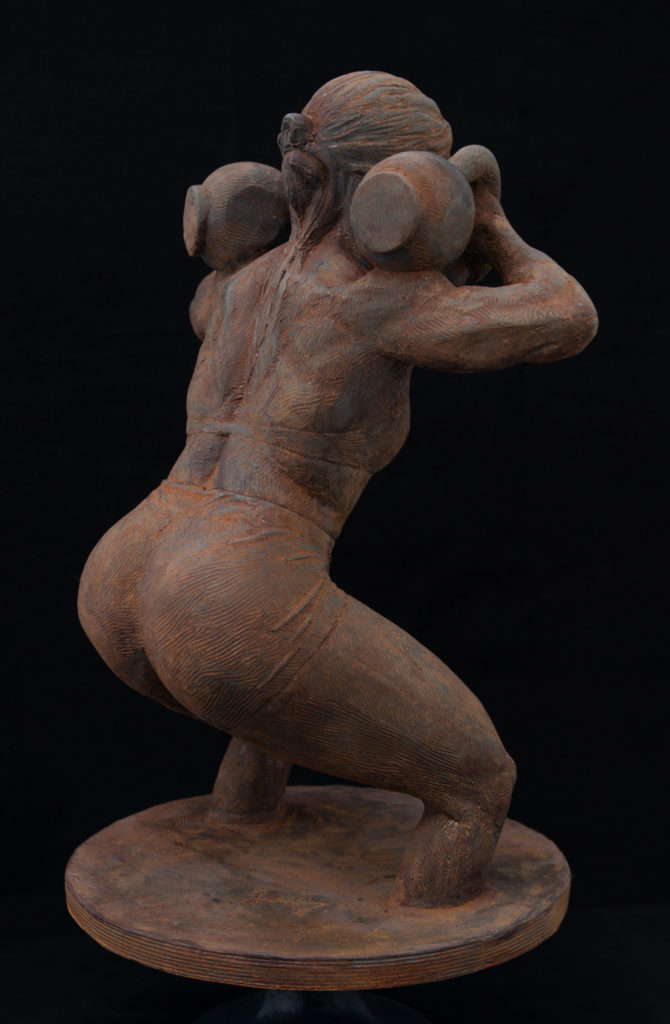 Rear three quarter view of female lifter in front squat.  The sculpture is set in cold cast iron with an aggressive iron oxide finish.